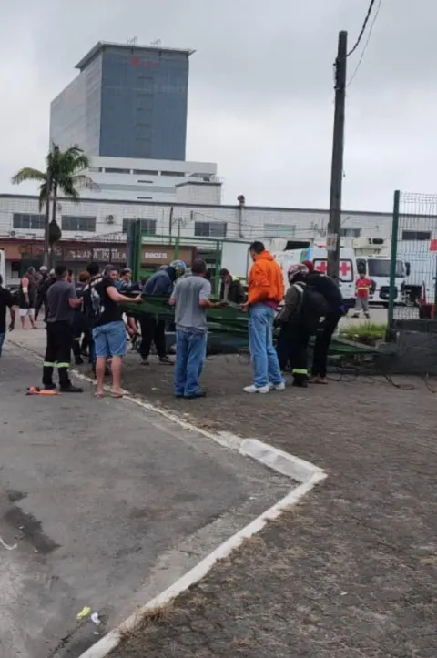 Motorista de caminhão perde o controle após manobra e derruba portão que atinge pedestre em Praia Grande.